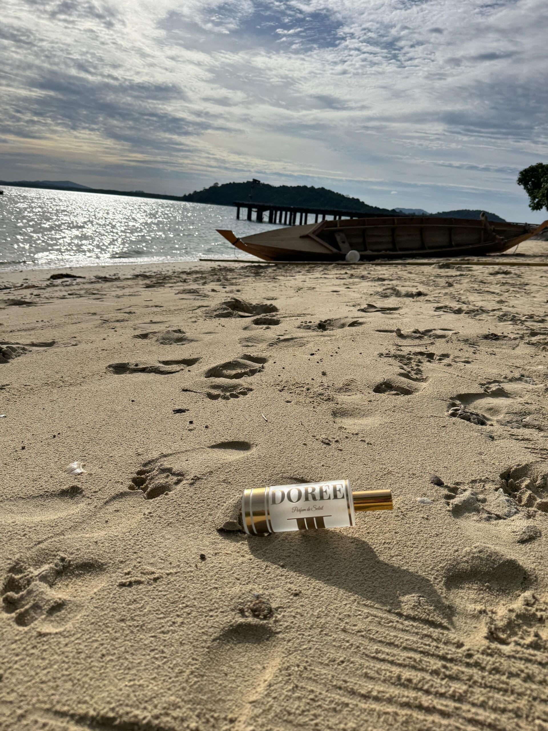 Dorée sunscreen on tropical beach with boat